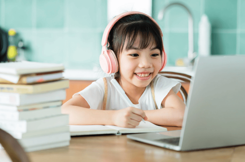 girl at laptop with pink headphones