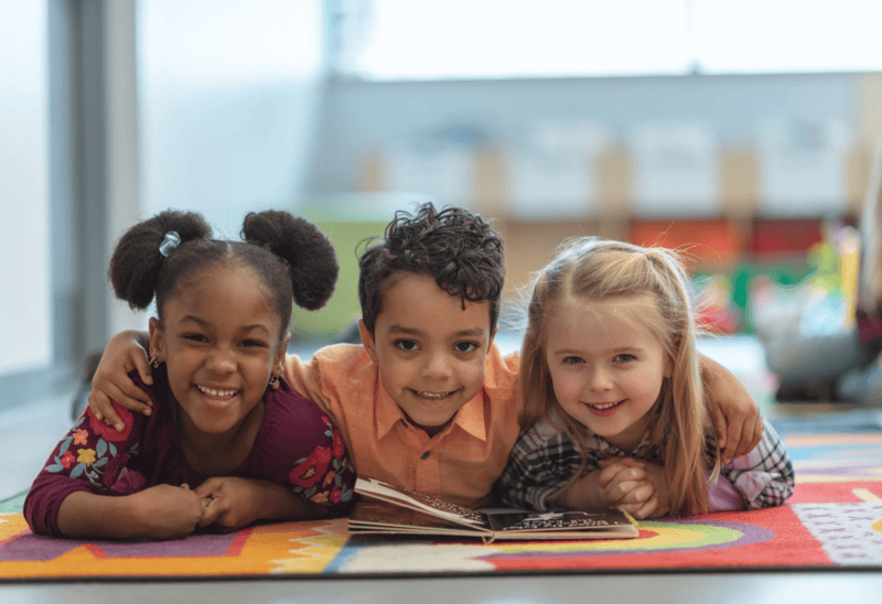 three kids with a book